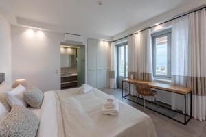 利昂尼迪翁Sampatiki Suites - 4 Star Seaview Luxury Suites With Breakfast And Spa - Opened 2024的酒店客房设有一张床、一张书桌和窗户。