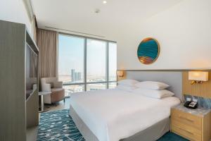 迪拜The First Collection at Jumeirah Village Circle, a Tribute Portfolio Hotel的卧室设有白色的床和大窗户