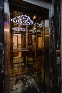 斯库台Ervini Boutique Hotel的一间设有玻璃门和镜子的房间
