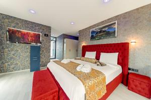 特拉布宗Air Barbaros Hotel Trabzon的一间卧室配有一张大床和红色床头板