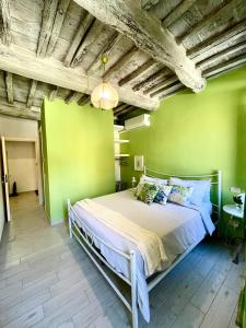 皮耶韦城La casa dei Mimmi的卧室设有一张位于绿色墙壁上的床铺