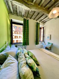 皮耶韦城La casa dei Mimmi的窗户客房内的一张带枕头的大床