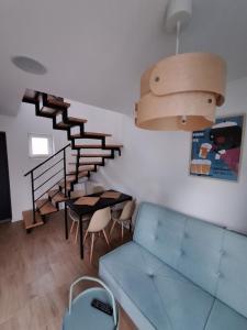 加茨比亚格拉Domki całoroczne Morzemoze的客厅设有蓝色的沙发和楼梯。