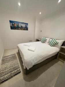 伦敦St Paul's London Apartments的卧室配有一张带白色床单和枕头的大床。