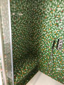 卡斯泰拉马莱COCCIU D’AMURI的浴室设有绿色和彩色瓷砖淋浴。