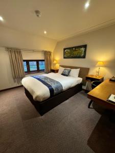 拉格比金狮酒店的一间卧室设有一张大床和一个窗户。
