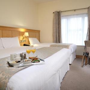 Irvinestown马洪酒店的酒店客房设有两张床和一盘食物