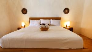 蒙波斯HOTEL NIETO MOMPOX, ubicado en el corazón del centro histórico, frente al rio magdalena en zona de malecón的一间卧室配有一张带两盏灯的大型白色床。