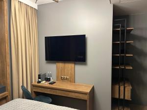 希奥利艾Four Sisters Luxury Rooms in Siauliai的酒店客房的墙上配有电视