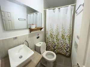 帕洛米诺Casa Colibri Palomino的浴室配有水槽、卫生间和浴帘
