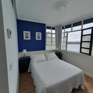 塔索内斯Hotel El Pescador的一间卧室配有一张蓝色墙壁的床