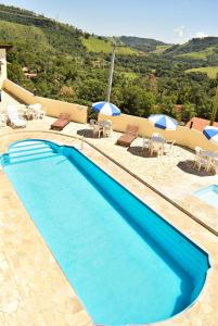 林多亚普萨达考尼提旅馆的一个带椅子和遮阳伞的蓝色游泳池