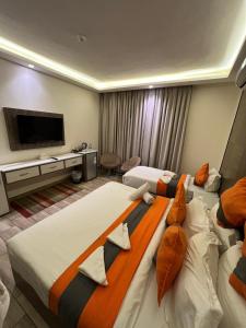 亚喀巴Sky Hotel的酒店客房设有两张床和一台平面电视。