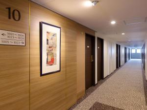 东京Keio Presso Inn Kanda的走廊上设有木墙,墙上挂着一幅画