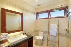 金巴兰Villa Allamanda by Kubu GWK的浴室配有盥洗池、卫生间和镜子。