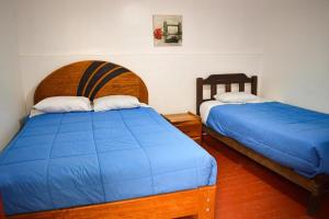 库斯科Fun Packers Hostel的两张睡床彼此相邻,位于一个房间里