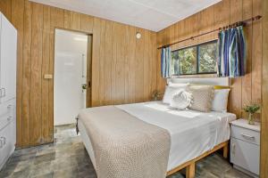 KioloaTasman Holiday Parks - Kioloa Beach的一间卧室设有一张大床和一个窗户。