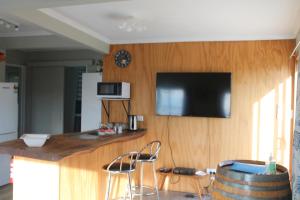 莫拉基Jacks place的厨房设有酒吧,墙上配有电视。