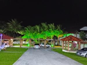 伊塔帕里卡Pousada Villa do Mar的一群棕榈树在晚上在院子里