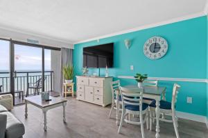 默特尔比奇Oceanfront Oasis的客厅设有蓝色的墙壁和桌椅
