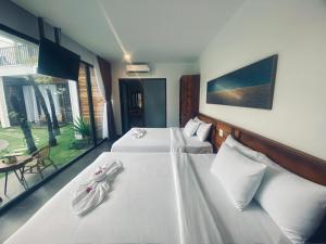 美奈Tuong Vy Boutique Hotel Mui Ne的酒店客房,配有两张带白色床单的床