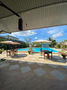 邦劳Buona Vita resort的游泳池旁带桌子和遮阳伞的天井