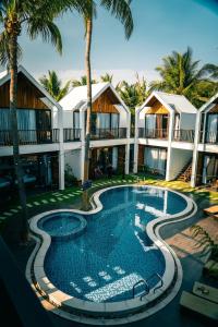 美奈Tuong Vy Boutique Hotel Mui Ne的棕榈树度假村前的游泳池
