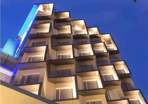 雅加达雅加达瓦希德哈西姆智选假日酒店的一座高大的建筑,上面有灯