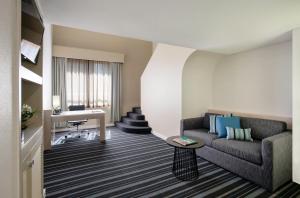 达尔文达尔文滨海希尔顿逸林酒店的带沙发和书桌的客厅