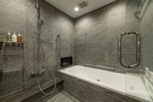 京都HOTEL MASTAY jingumichi的带淋浴和浴缸的浴室