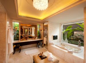 三亚三亚海棠湾万达瑞华度假酒店的一间带浴缸和大镜子的浴室