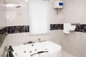 莱基BTT Homes的白色的浴室设有浴缸和窗户。