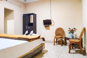 BangkoRedDoorz @ Hotel Keluarga Bangko的卧室配有一张床和一张桌子及椅子