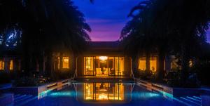三亚三亚海棠湾万达瑞华度假酒店的一座晚上设有游泳池的房子
