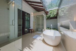 停泊岛布布别墅酒店的浴室配有大型白色浴缸和水槽