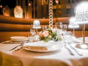迪拜Golden Sands Boutique Hotel-Dubai Creek的一张桌子,上面有白色的桌子,上面有盘子和玻璃杯