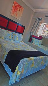 梅富根DREAMLAND GUEST HOUSe的一间卧室配有一张带蓝色棉被的床和窗户。