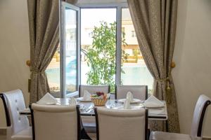 阿尔布亚米Al Salam Grand Hotel & Resort的一间带桌子和大窗户的用餐室