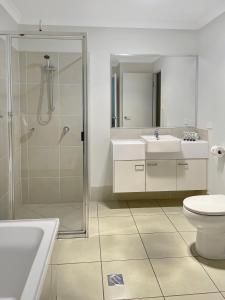埃默拉尔德Direct Collective - Villas on Rivergum的带淋浴、两个盥洗盆和卫生间的浴室