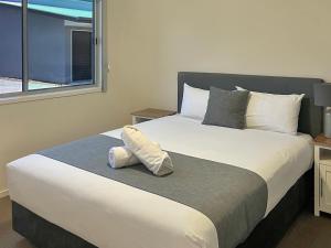 埃默拉尔德Direct Collective - Villas on Rivergum的卧室配有一张大白色床和窗户
