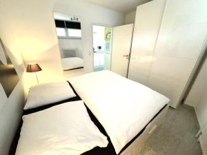 蒂门多弗施特兰德- Bel Etage - Bergstrasse 35的一间小卧室,配有两张床和镜子