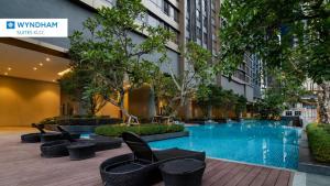 吉隆坡Wyndham Suites KLCC的酒店庭院设有游泳池和椅子