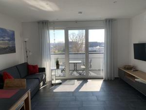 腓特烈港Holiday apartment Hildebrand Lake Constance的带沙发和大窗户的客厅