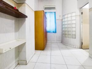 雅加达Kartini Residence RedPartner的浴室设有黄色门和白色瓷砖地板。
