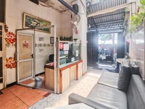 雅加达Kartini Residence RedPartner的带沙发和柜台的客厅