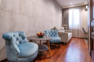 埃里温Arch Apart Hotel的客厅配有蓝色的椅子和桌子