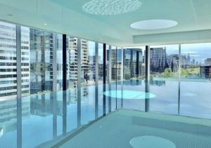 墨尔本普瑞德福克纳海湾景公寓（六十二号）的大型客房设有玻璃窗和游泳池