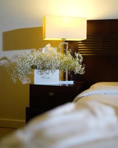 贝鲁特巴黎人酒店的配有一盏灯和一束鲜花的床头柜