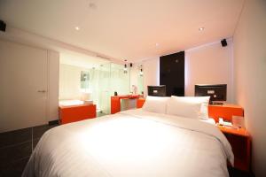 首尔Jongno Hotel Pop Leeds Premier的卧室配有一张白色大床和2个显示器