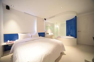 首尔Jongno Hotel Pop Leeds Premier的一间带白色大床的卧室和一间浴室